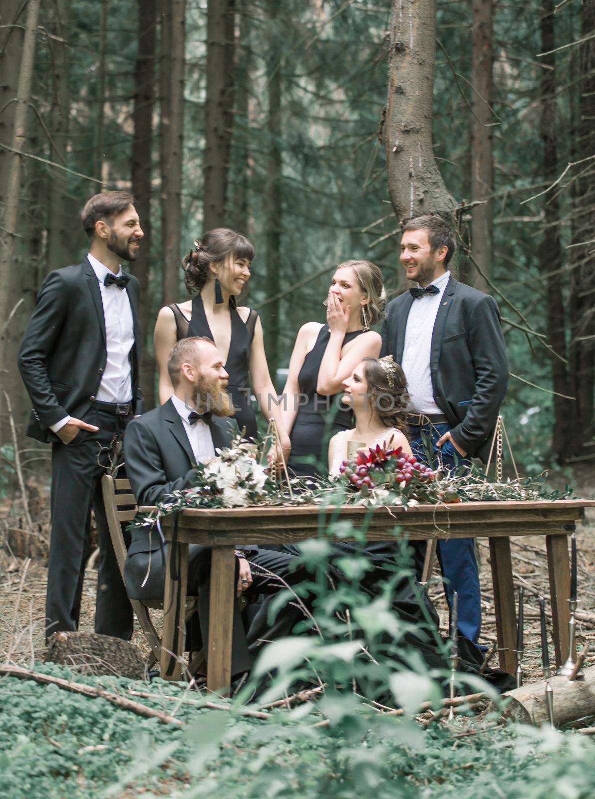 bride and groom with friends at a picnic in the pine forest by SmartPhotoLab