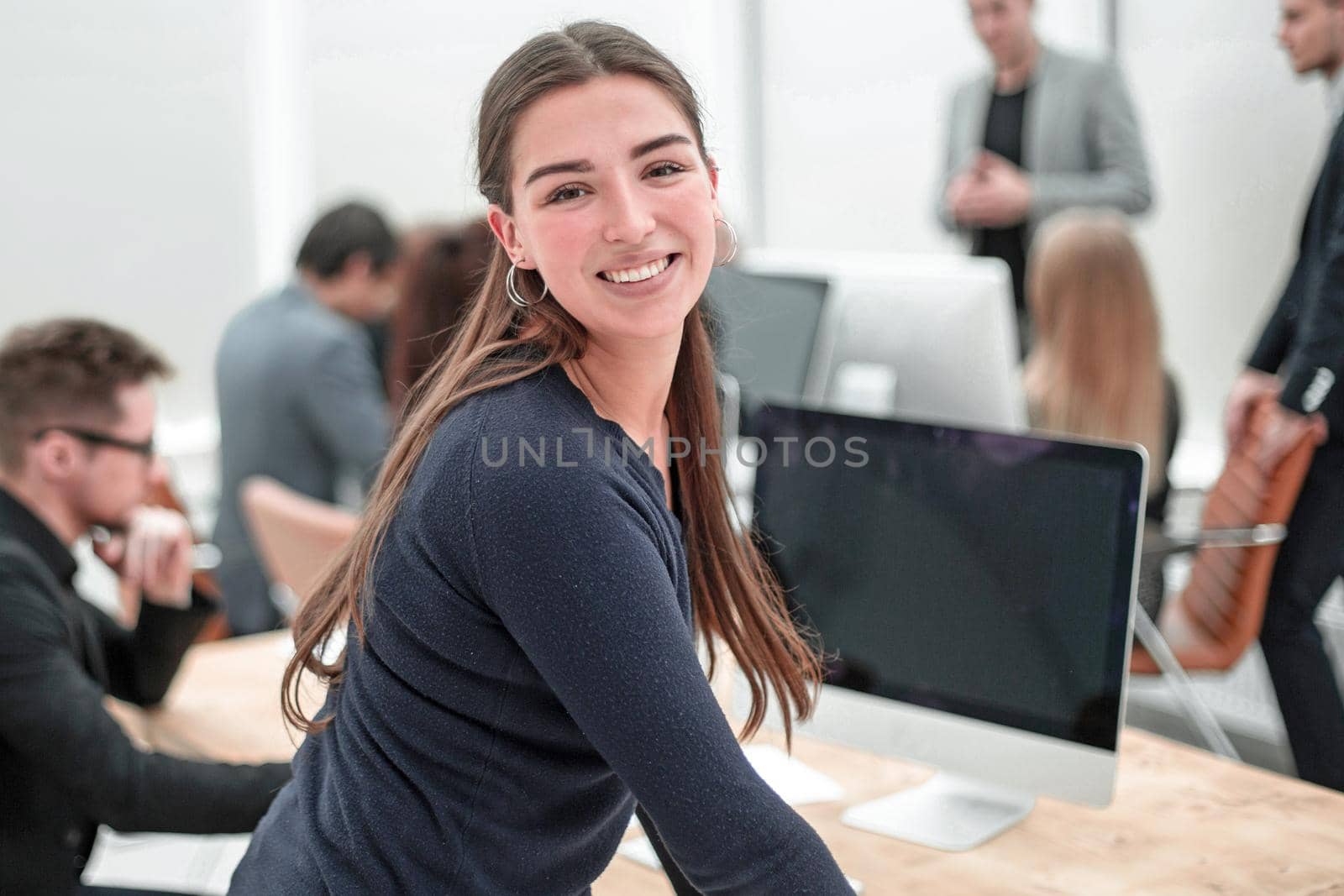 rear view. young business woman standing near an office Desk. photo with a copy-space