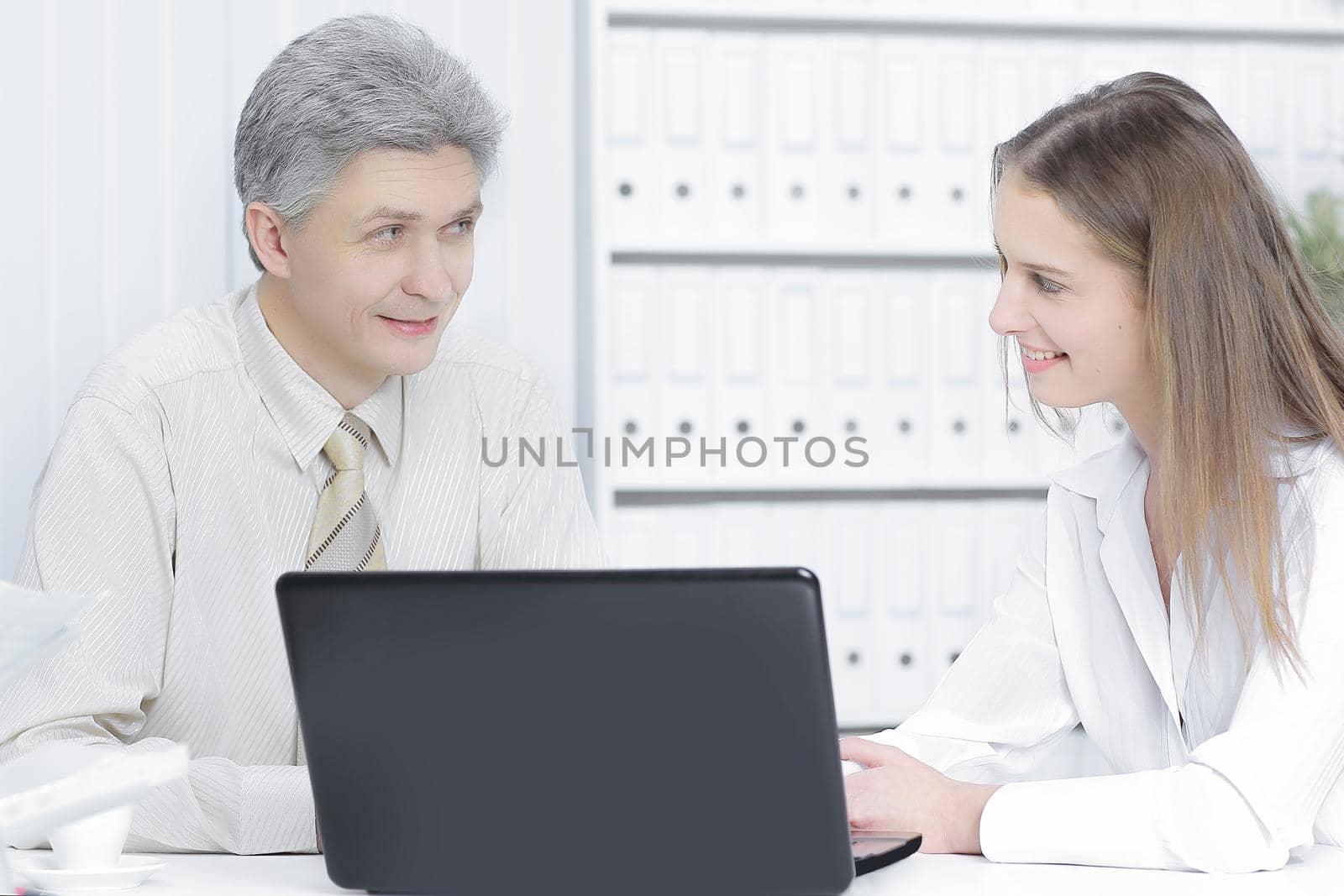 two members of the company sitting behind a Desk by SmartPhotoLab