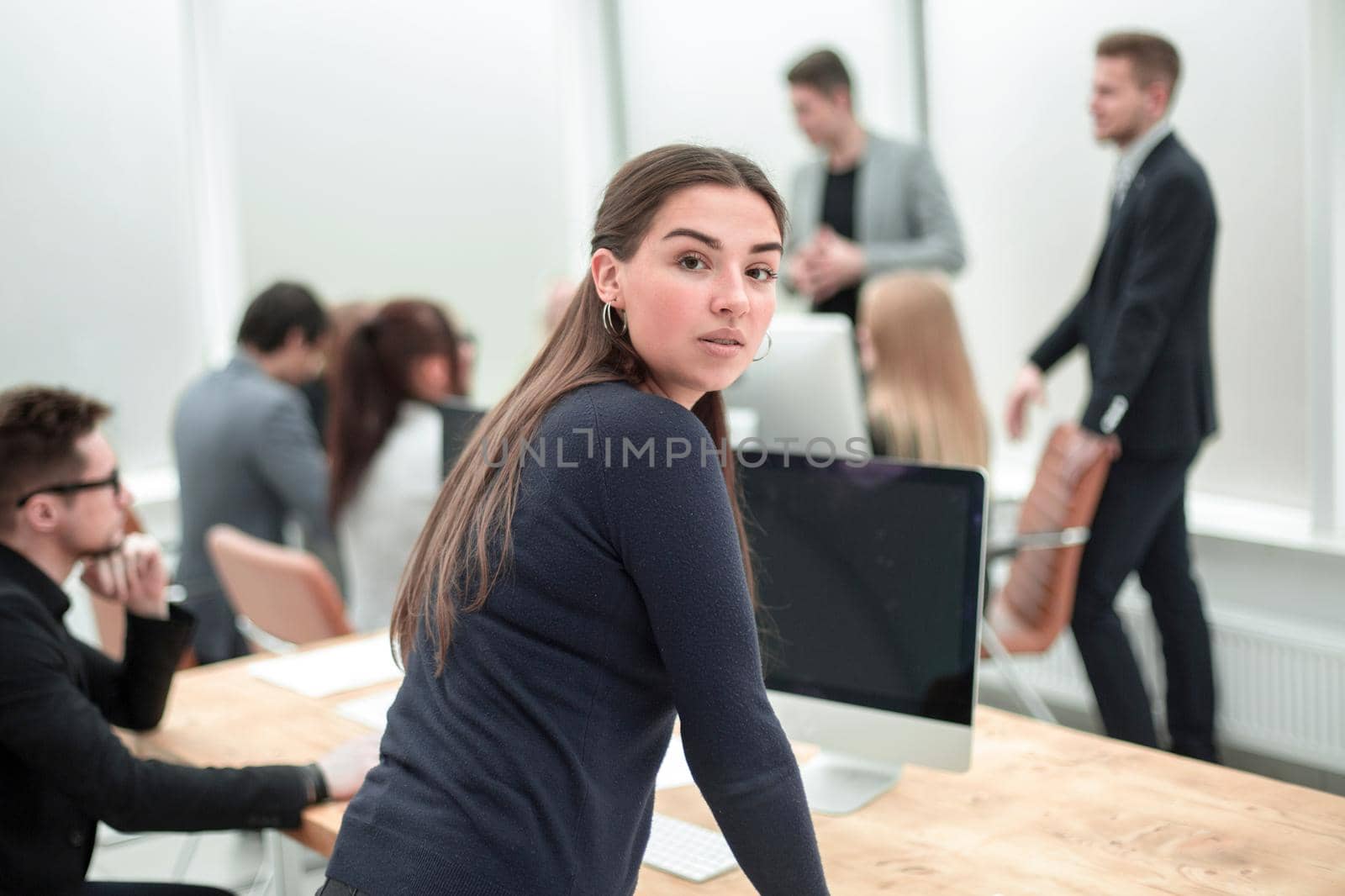 rear view. young business woman standing near an office Desk. photo with a copy-space