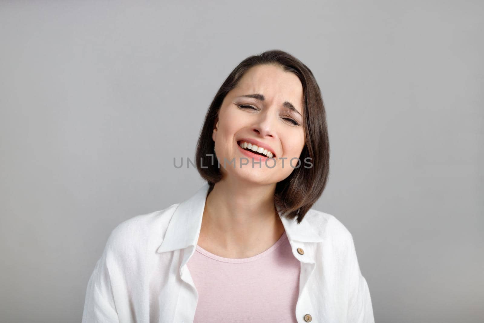 Human face expressions and emotions. Portrait of laughing young brunette multiethnic woman in pink tank and white shirt by Rom4ek