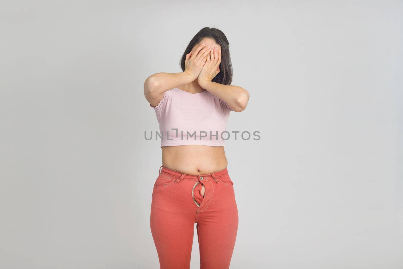 Upset young woman with slightly overweight. Diet, overweight, obesity concept by Rom4ek