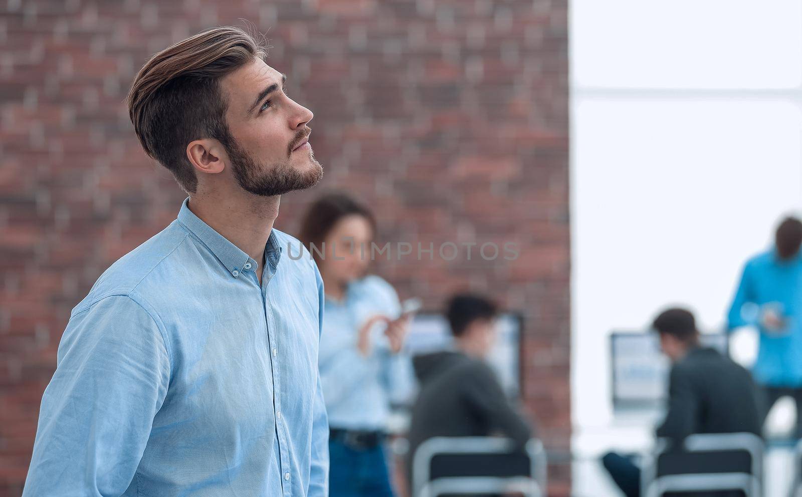 Young businessman looking away while working in the office. Copy space.