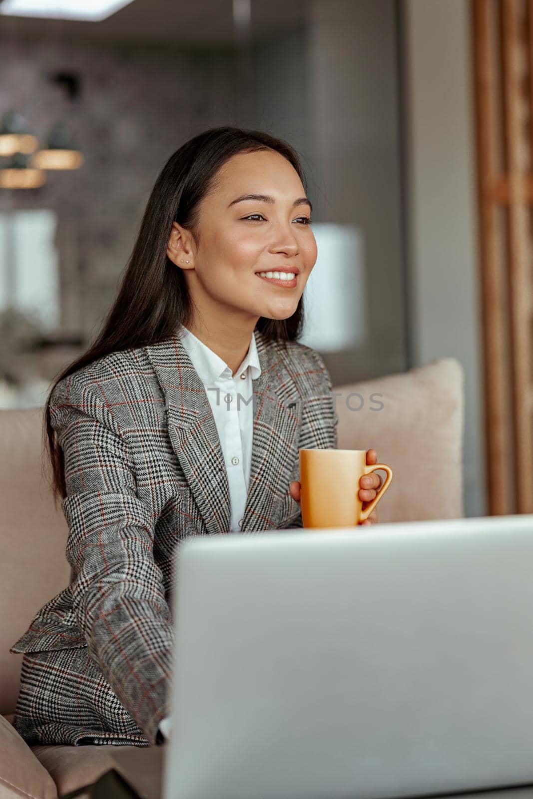 Attractive asian business woman working laptop and drink coffee in cozy office