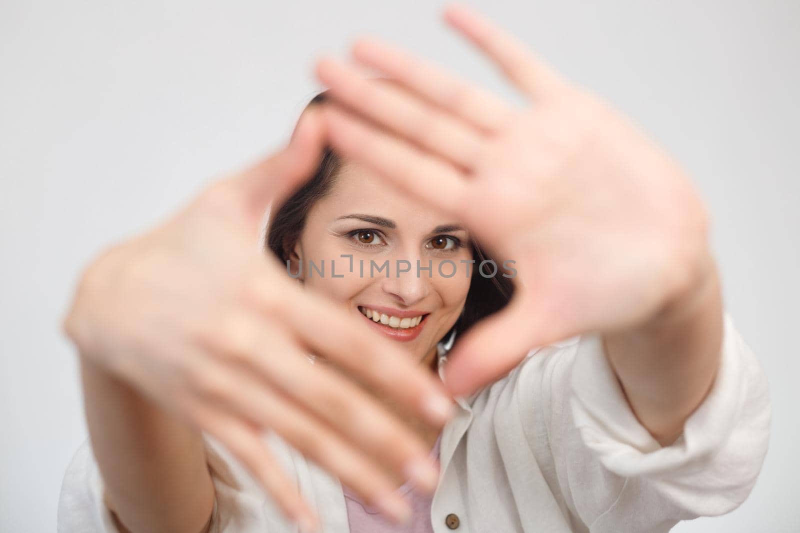 Hand framing woman portrait. Selective focus on face.