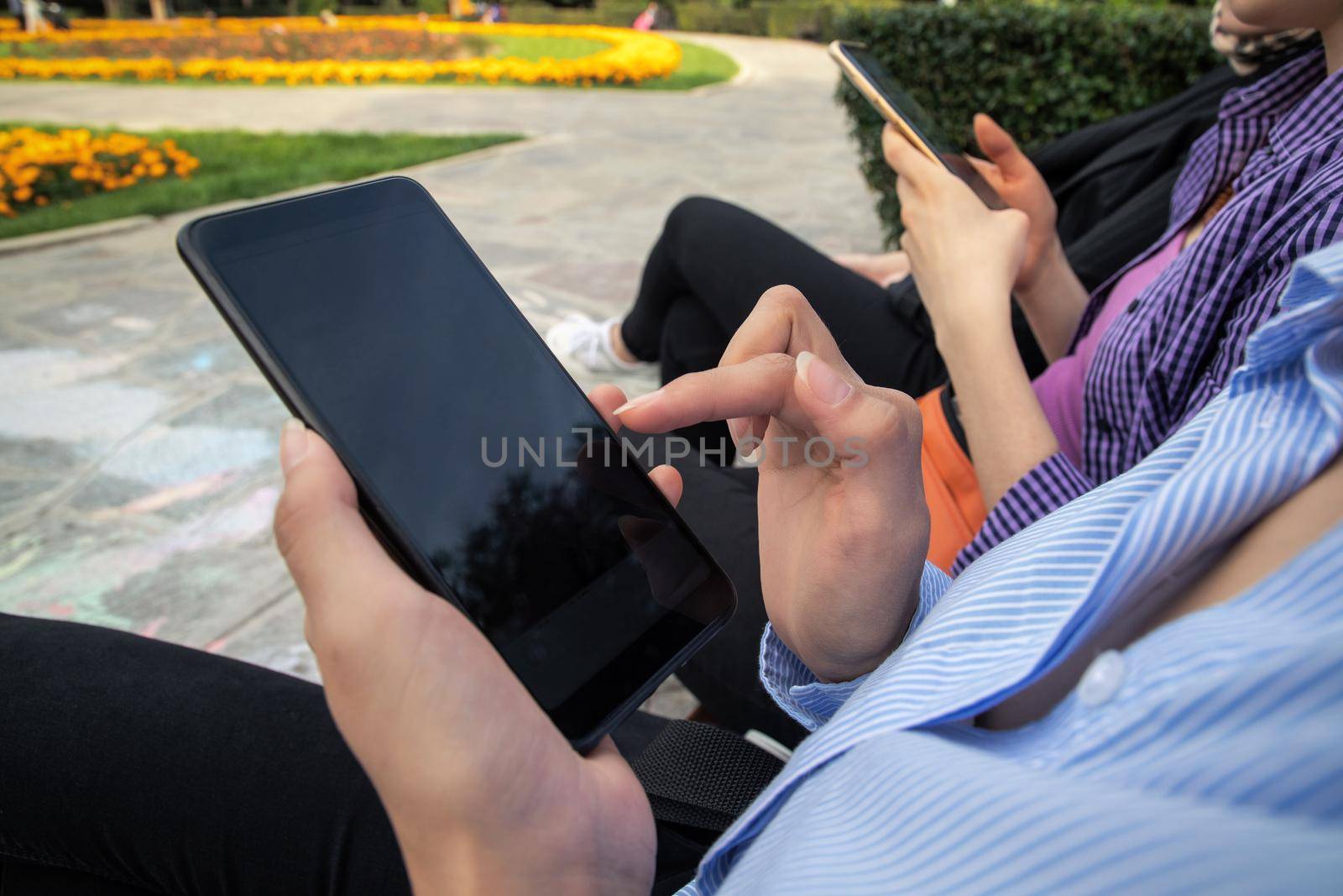 Closeup shot of young woman chatting with family at social networks, sunlight outdoor on the background.