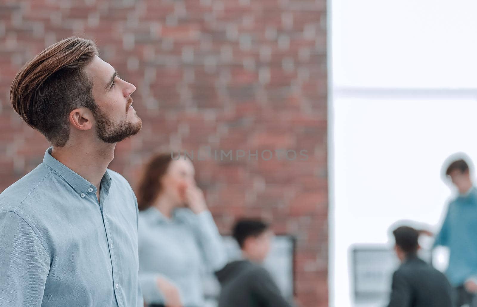 Young businessman looking away while working in the office. by asdf