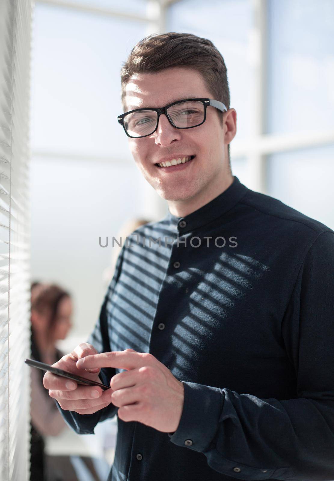 young pensive businessman uses the phone in the office by asdf