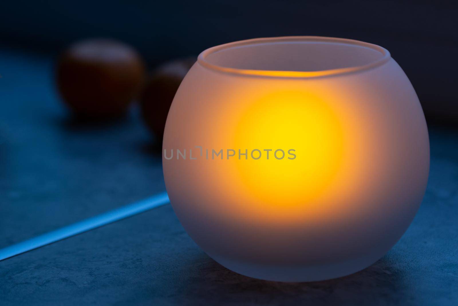 Frosted glass candlestick with a burning candle