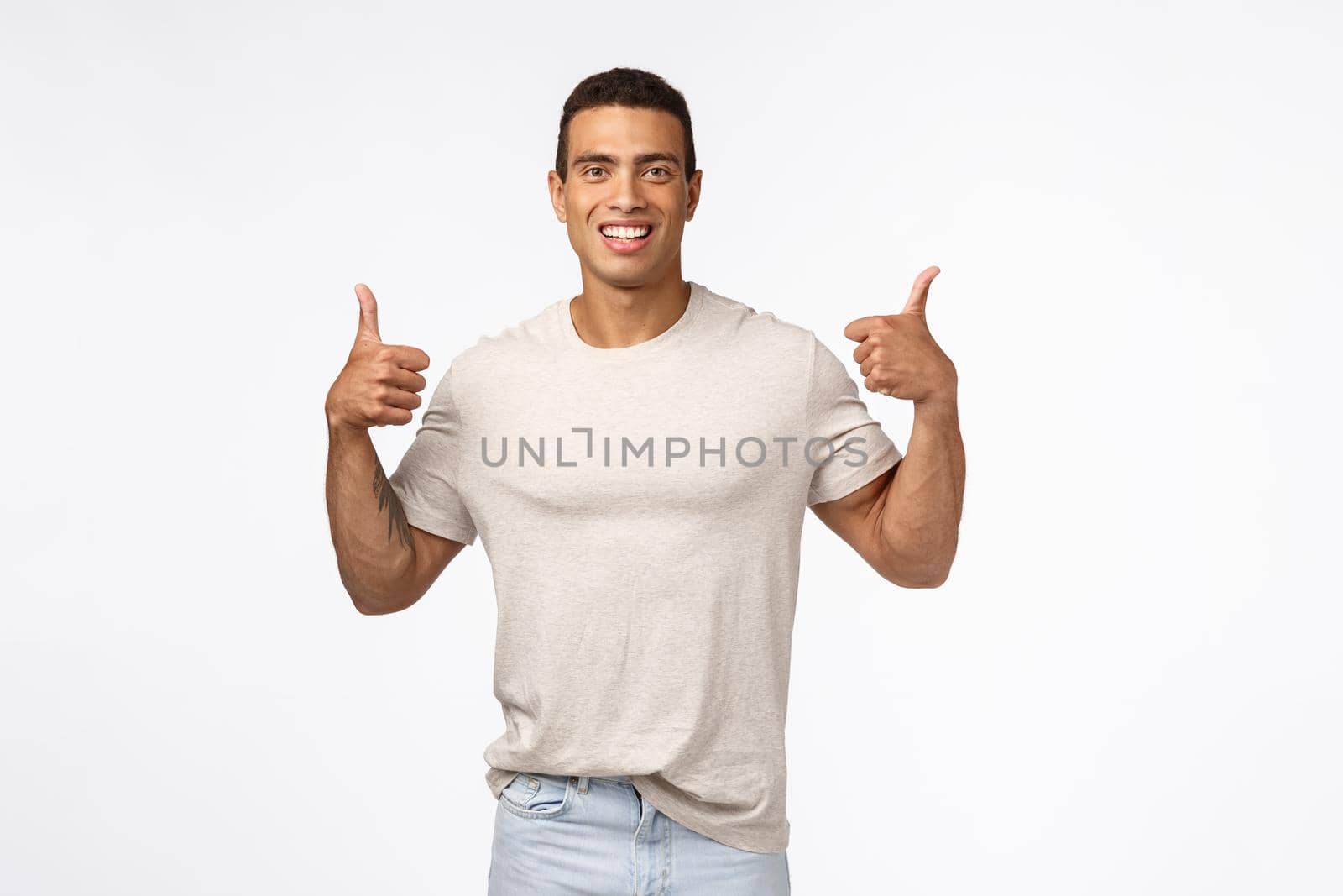 Sounds good. Assertive, optimistic handsome strong man showing thumbs-up. Young athlete agree with new training program, smiling happily, give positive reply, approve awesome idea, white background.