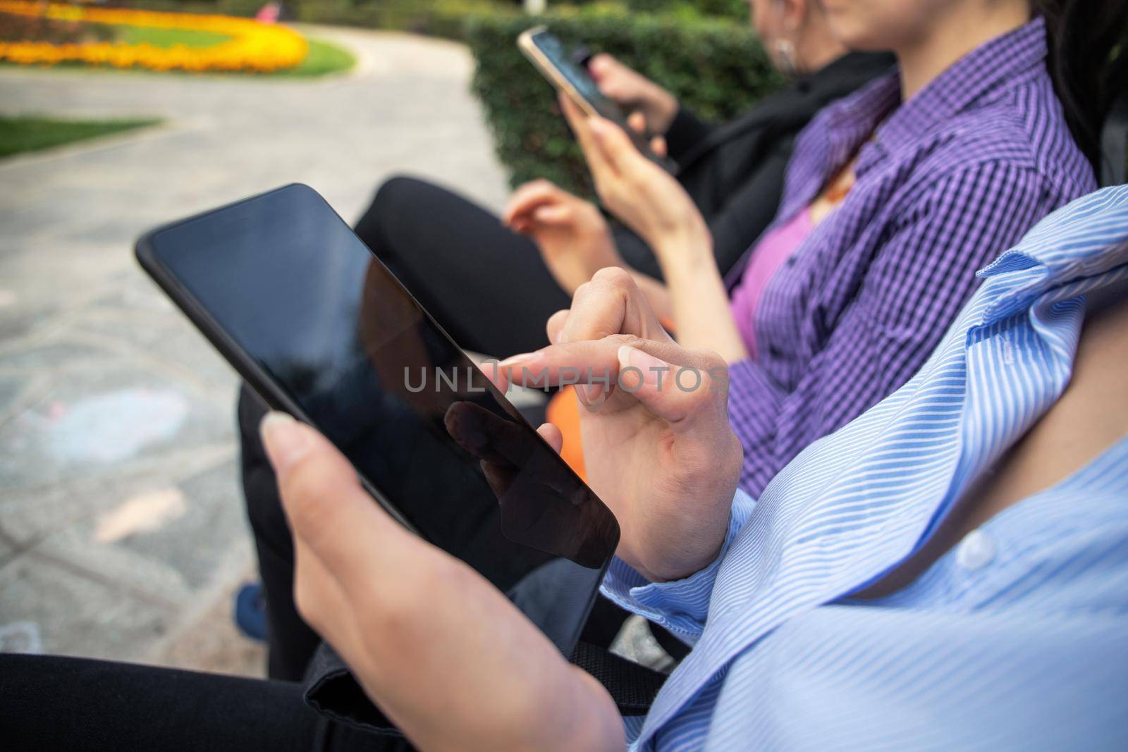 Womans hands using smartphone outdoor in the park