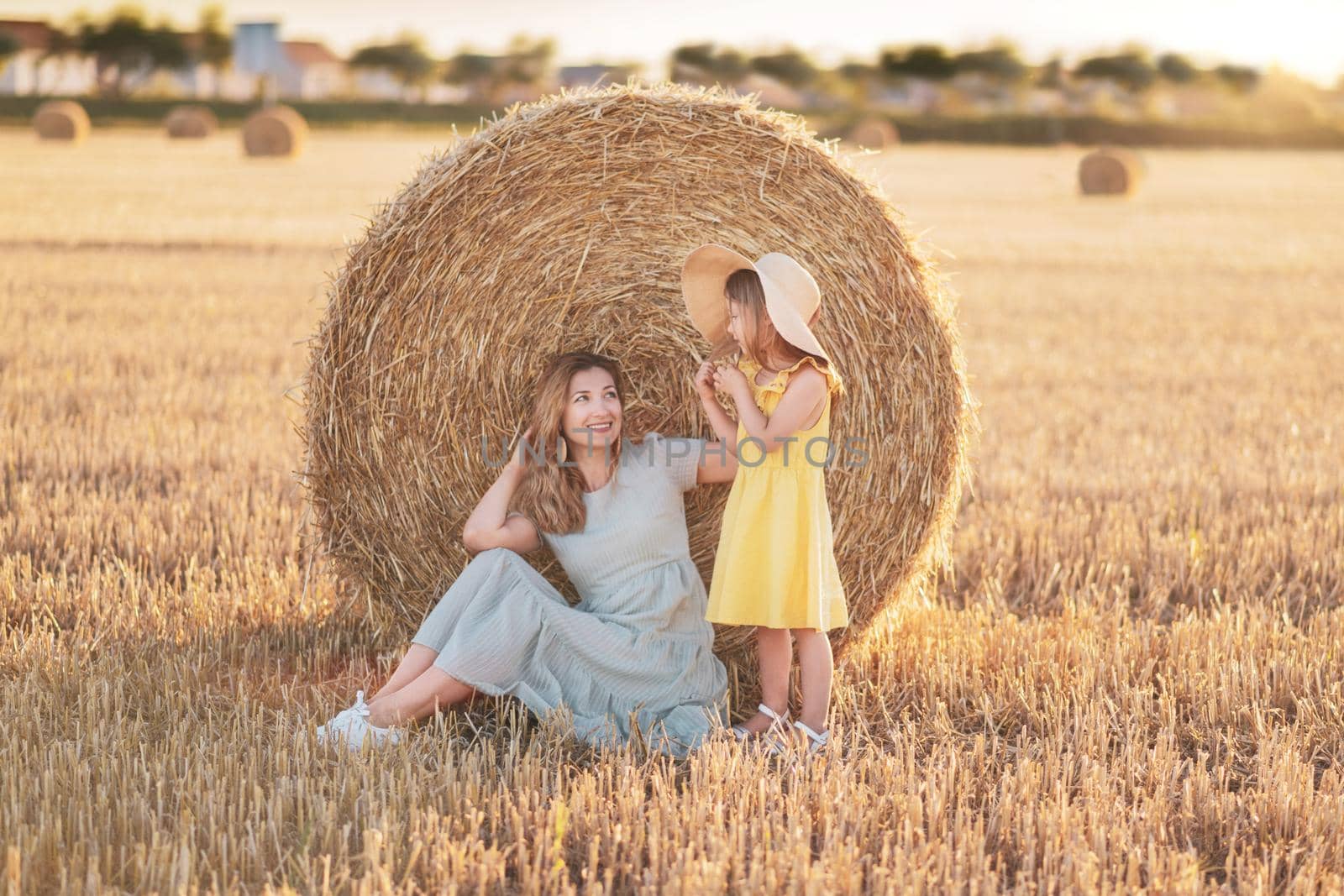 Mother and daughter near bales of wheat Countryside