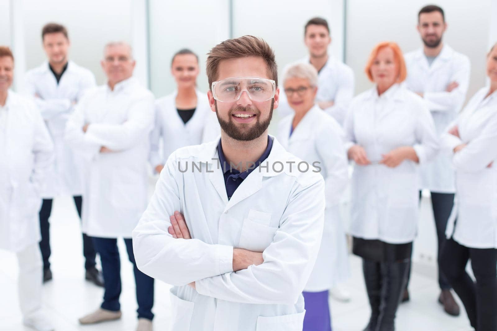 confident scientific leader standing in front of a team of young scientists. concept of health protection.