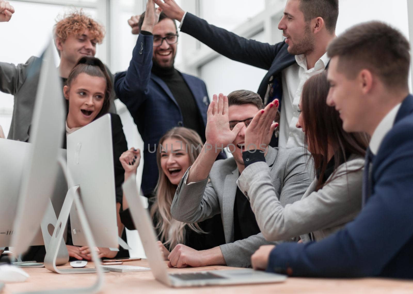 happy business team cheering near the desktop. success concept