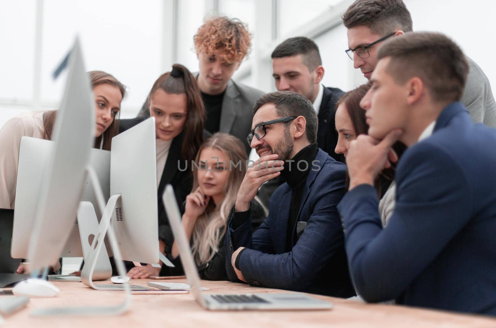 team of young employees looking together at a computer screen. success concept