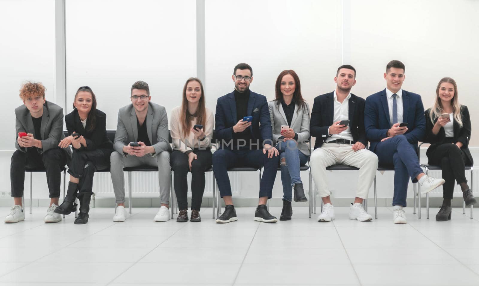 group of diverse young business people looking at their smartphone screens. photo with copy space