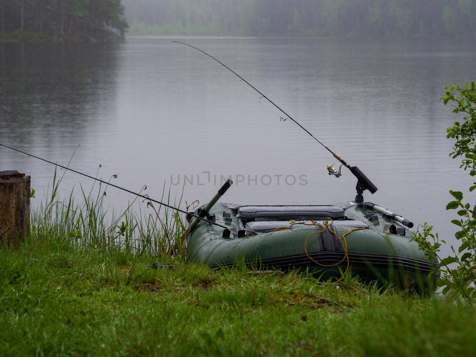 Inflatable boat with fishing rods on the lake by Andre1ns