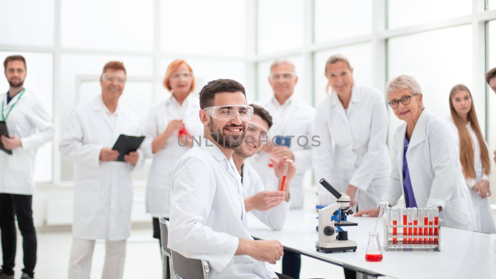 close up. smiling scientist sitting at a laboratory table .