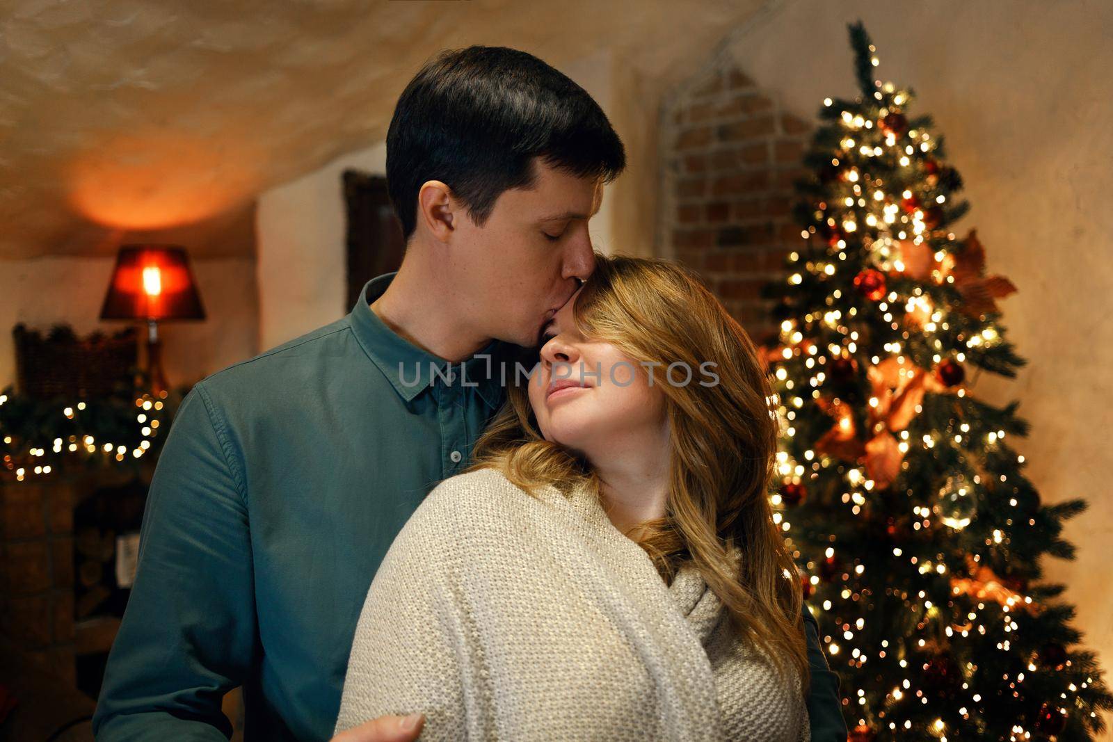 Beautiful caucasian middle aged couple kissing in new year interior by Rom4ek