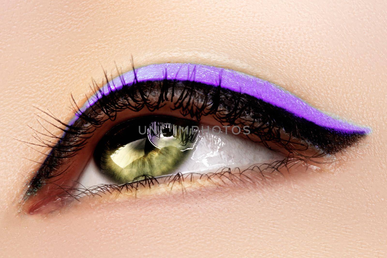Beautiful Macro Shot of Female Green Eye with Makeup. Perfect Shape of Eyebrows, Purple Eyeliner. Cosmetics and Make-up. Close-up Beauty Photo