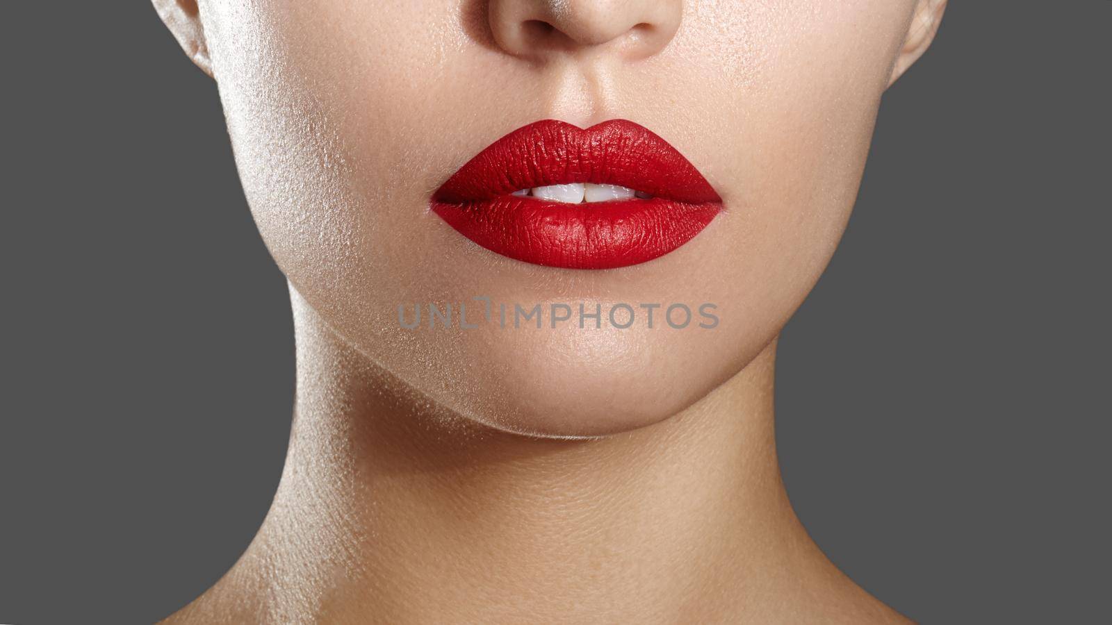 Cosmetics, Makeup and Trends. Bright Lip Gloss and Lipstick on Lips. Closeup of Beautiful Female Mouth with Red Lip Makeup. Beautiful Part of Female Face. Perfect Clean Skin. Horizontal