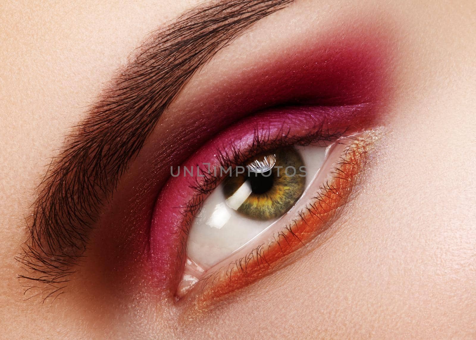 Beauty Close-up of Beautiful Female Eye. Celebrate Fashion Make-up with Red Eyeshadows. Christmas or Valentines Day Makeup. Perfect Eye Brows Shape