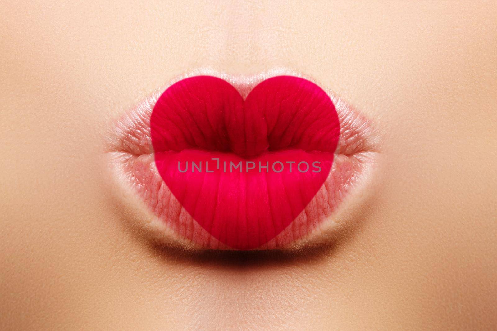 Valentine Heart on beautiful female Lips. Sweet Kiss. Love Makeup for Valntines Day. Cute Shape Heart like Symbol of Love. Celebrate Lip Make-up on macro shoot