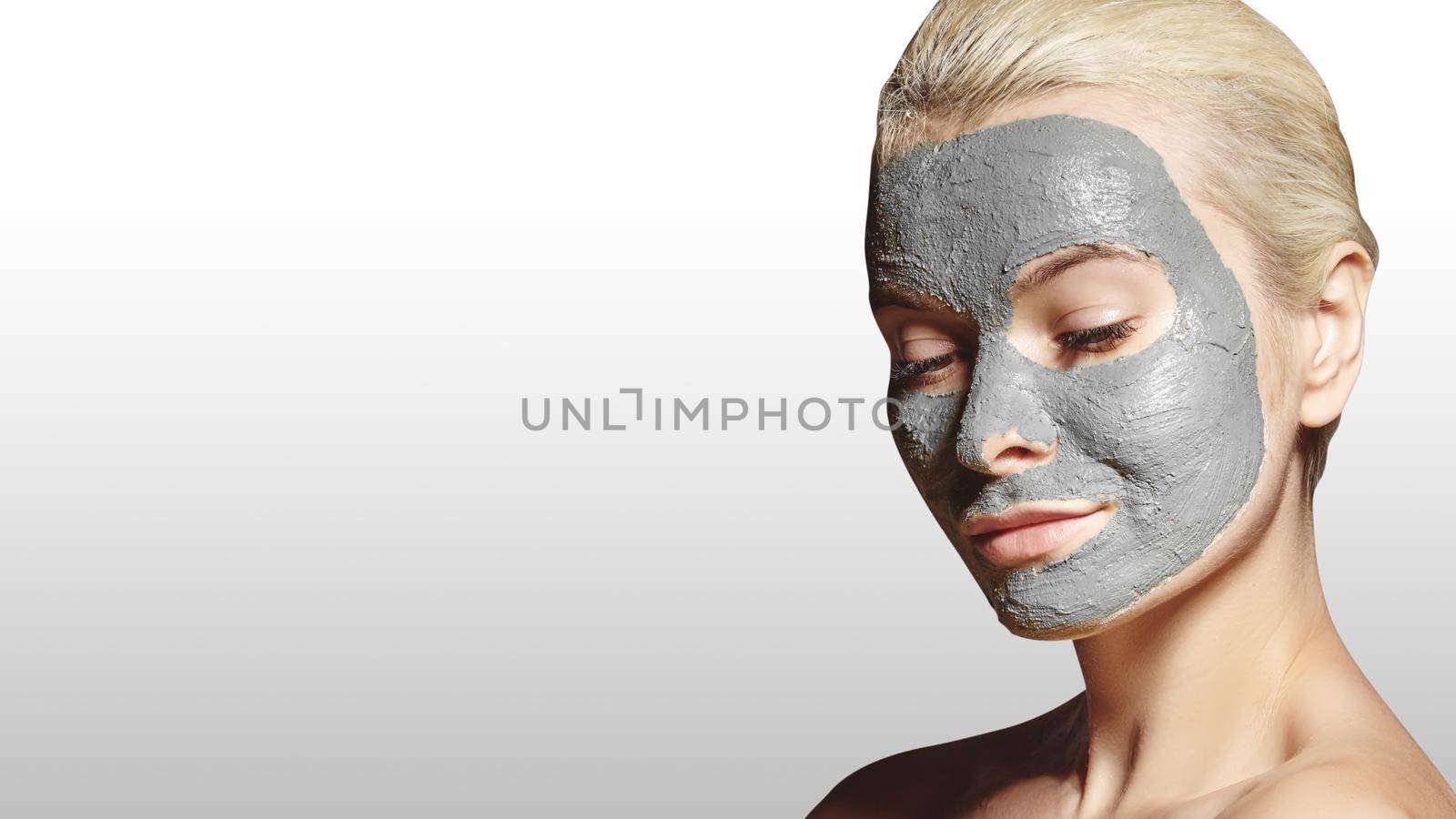 Beautiful Woman Applying White Facial Mask. Beauty Treatments. Spa Girl Apply Clay Facial mask on grey background by MarinaFrost