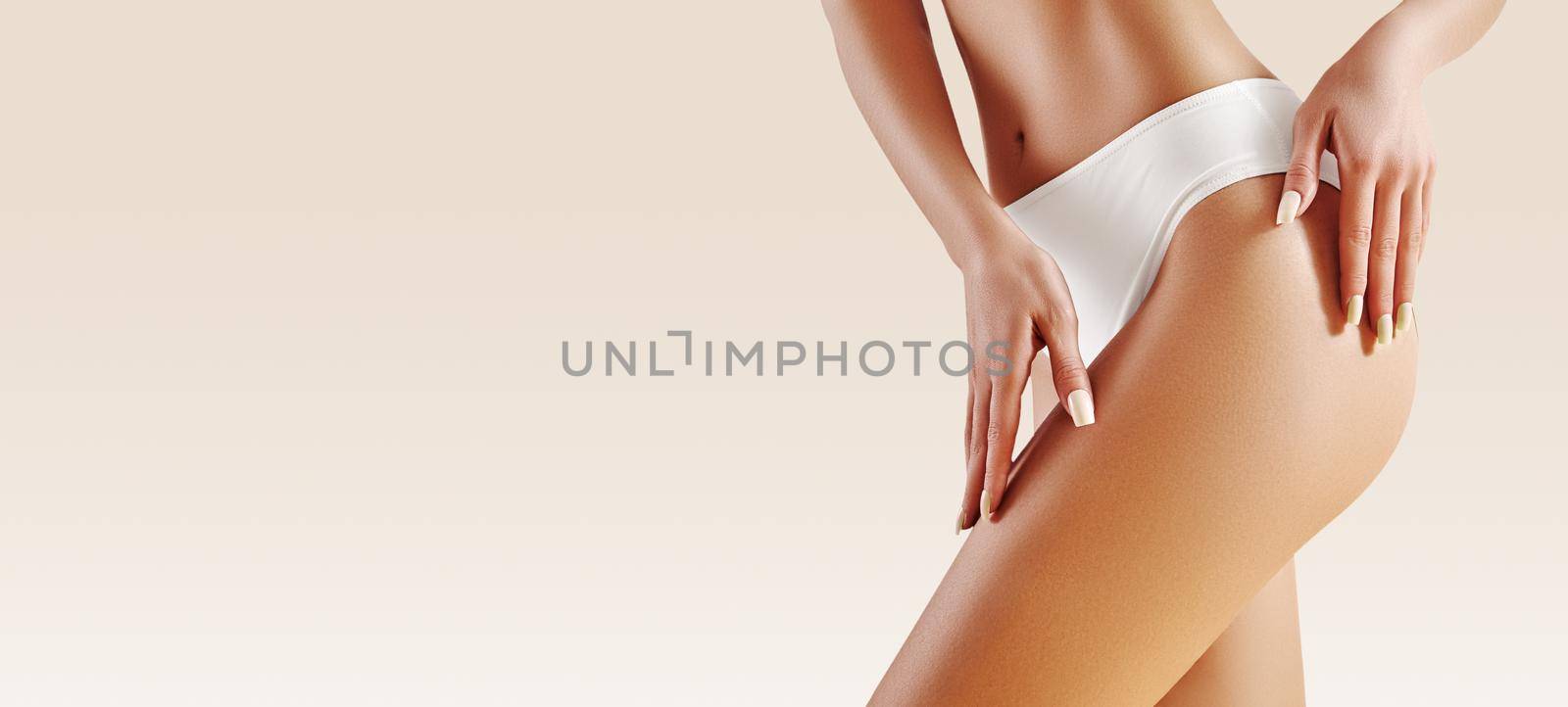 Spa and wellness. Healthy slim body in white panties. Beautiful sexy hips with clean skin. Fitness or plastic surgery. Perfect buttocks without cellulite.