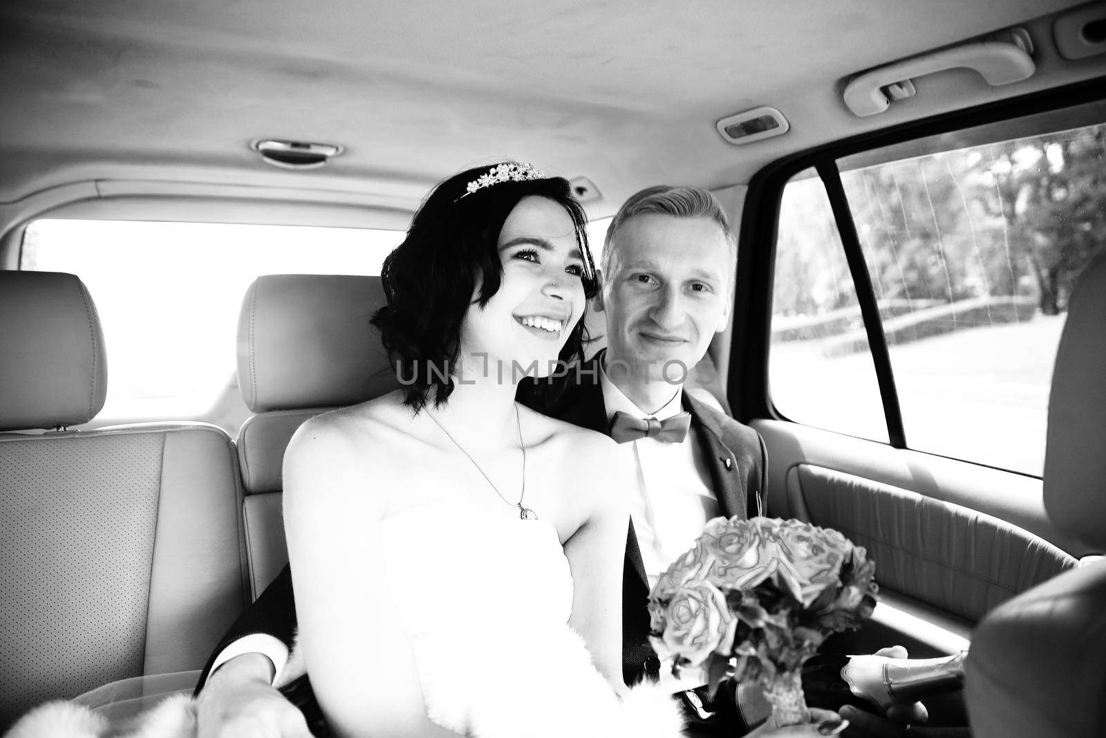 photo in retro style .the couple sitting in the wedding car.