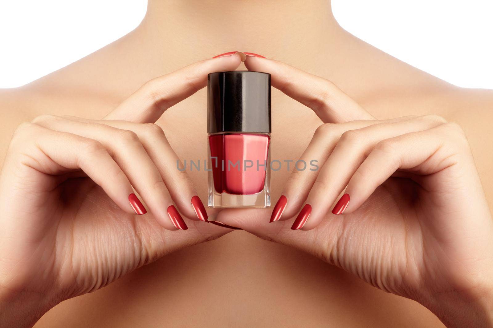 Manicured nails with red nail polish. Manicure with bright nailpolish. Fashion manicure. Shiny gel lacquer in bottle.