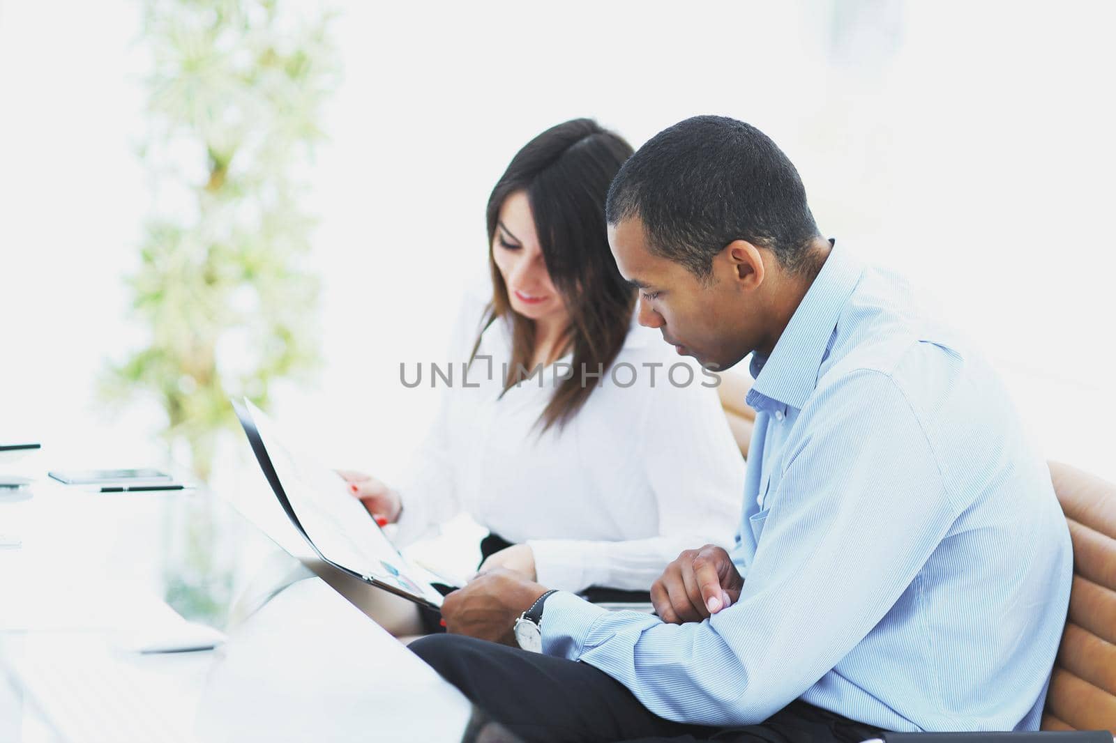 business colleagues discussing documents sitting at Desk by SmartPhotoLab
