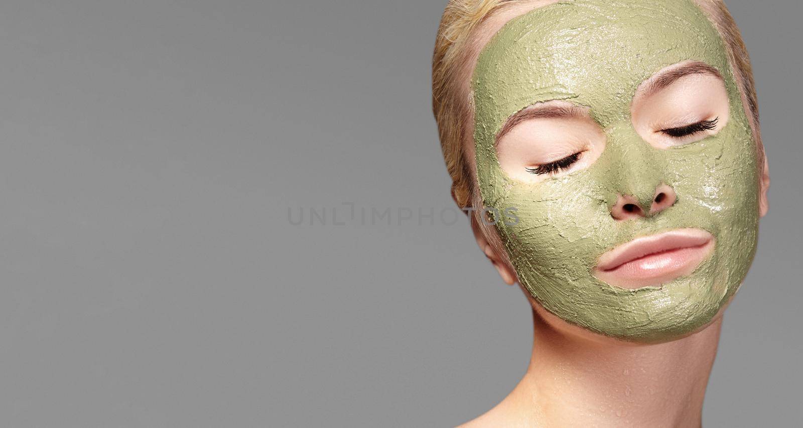 Beautiful Woman Applying Green Facial Mask. Beauty Treatments. Close-up Portrait of Spa Girl Apply Clay Facial mask by MarinaFrost