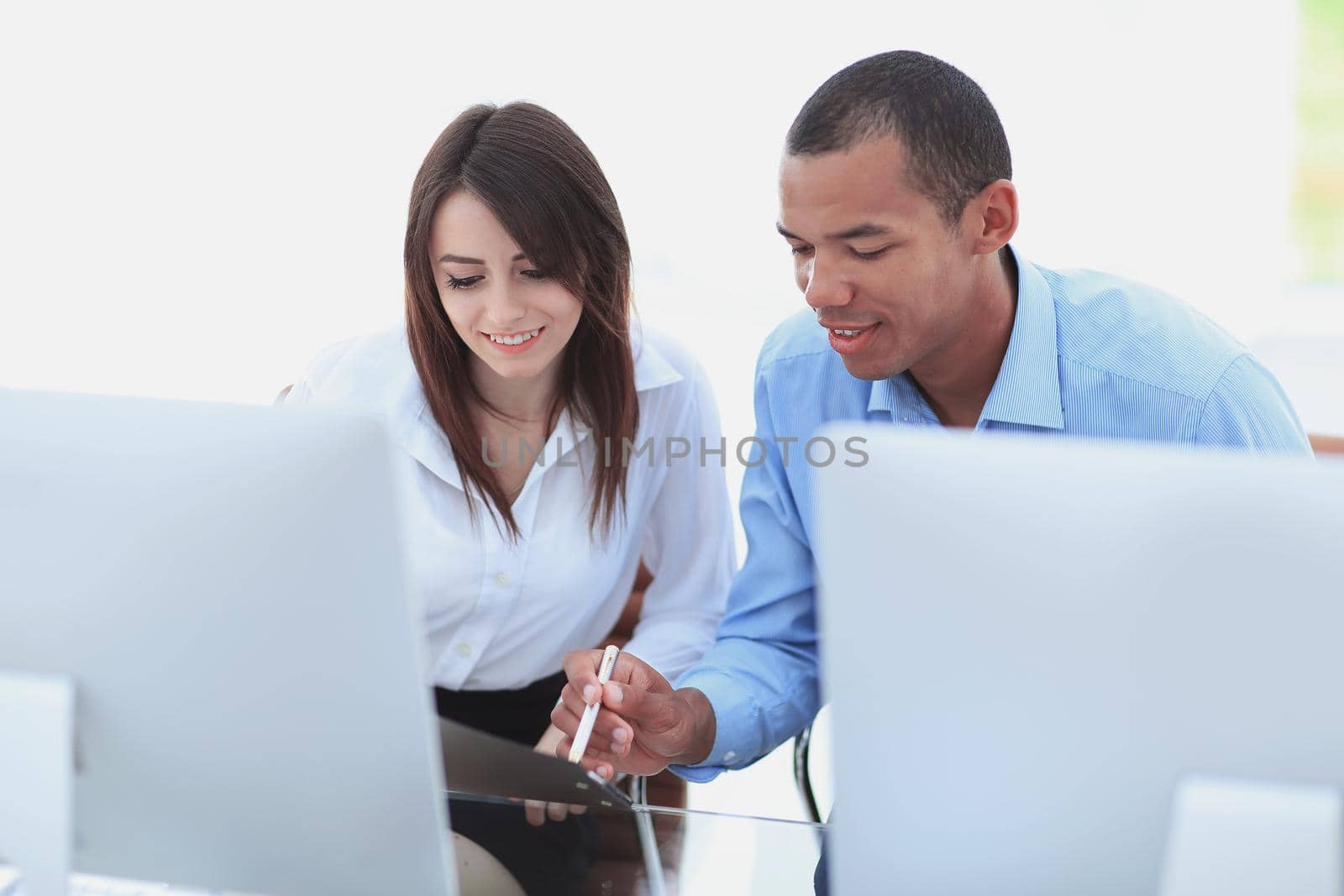employees discussing financial documents sitting at a Desk by SmartPhotoLab
