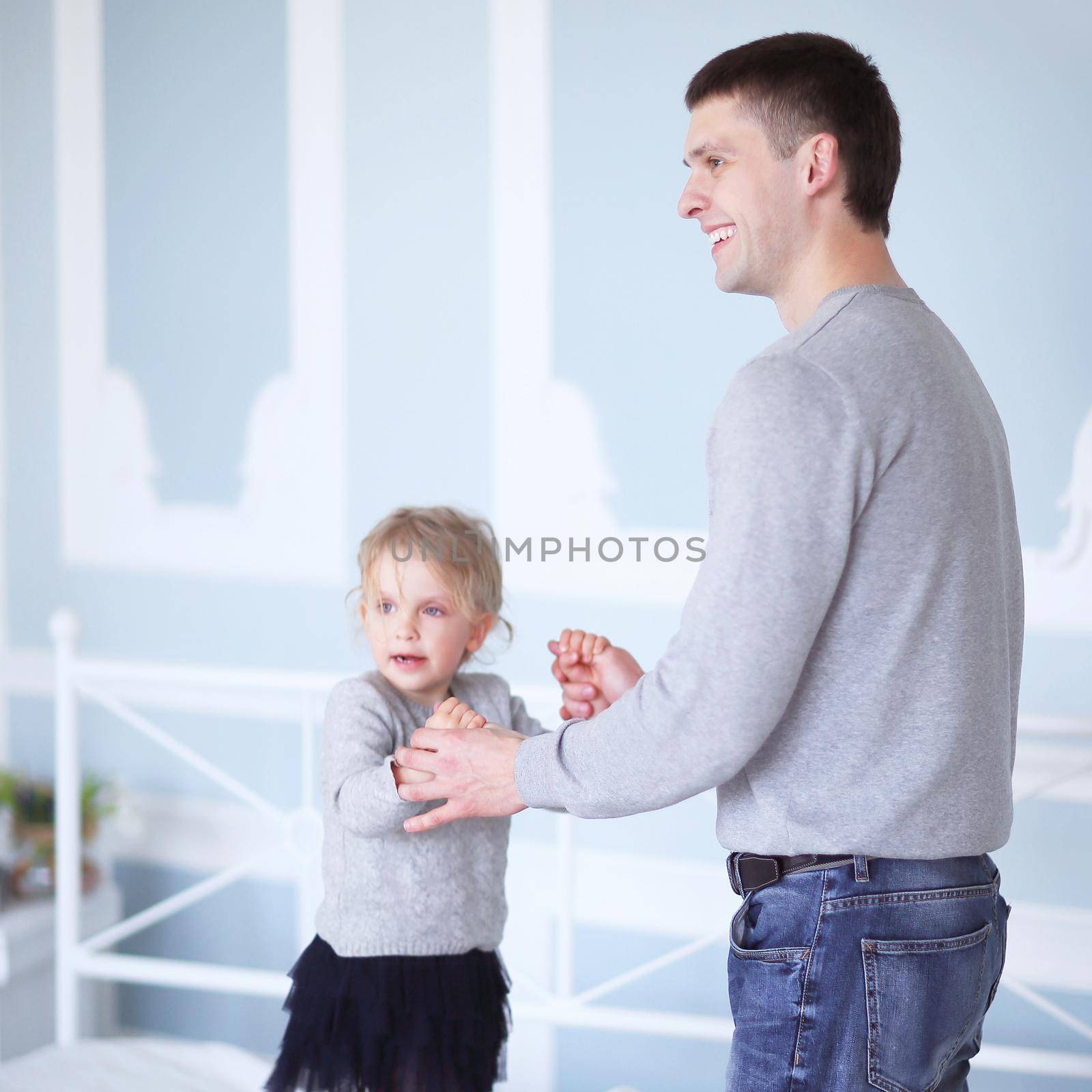 dad plays with daughter on the bed in the bedroom.photo with copy space