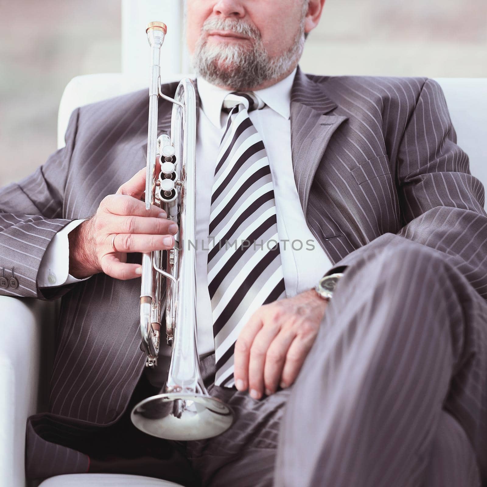 adult male musician sitting in a chair by SmartPhotoLab
