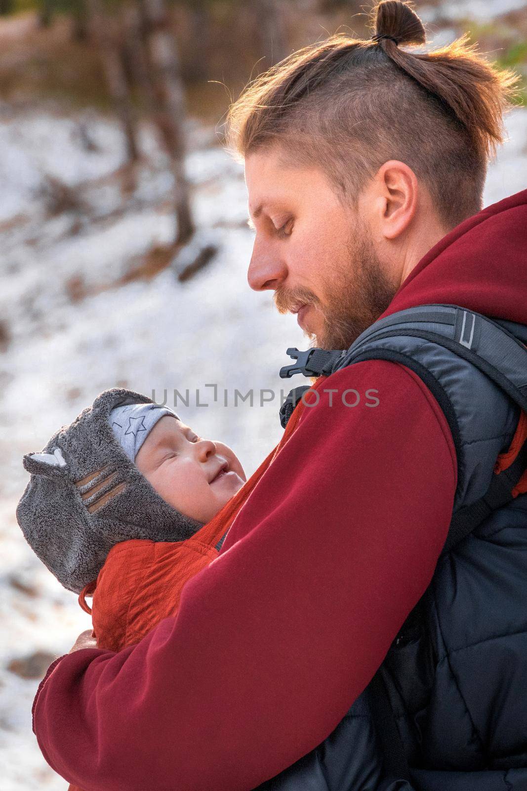 Close-up vertical lifestyle portrait of father an his baby son while walking outdoor.
