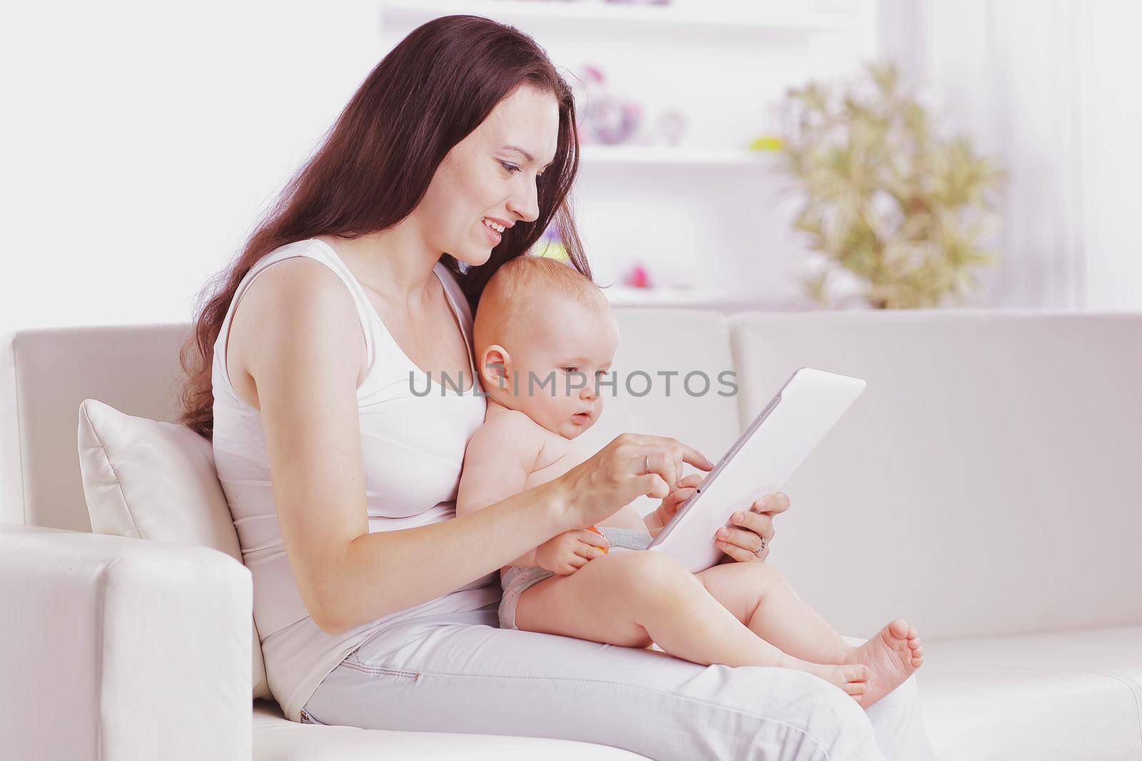 mother shows the baby pictures on a digital tablet.people and technology