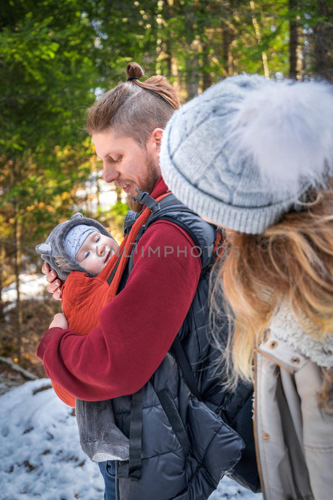 Portrait of young babywearing family with his son in baby sling, winter travel outdoor by Rom4ek