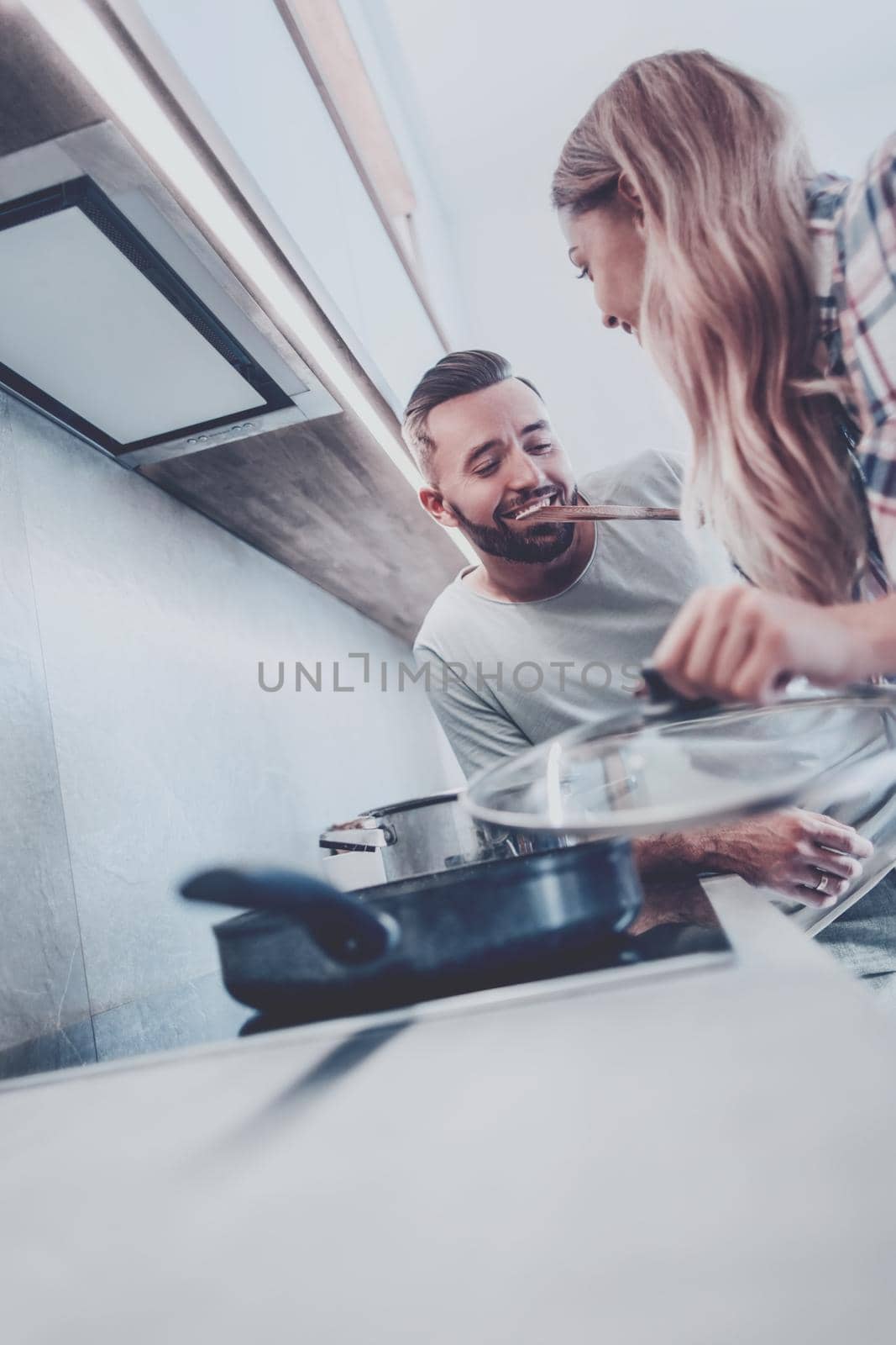young husband and wife cook dinner together by asdf