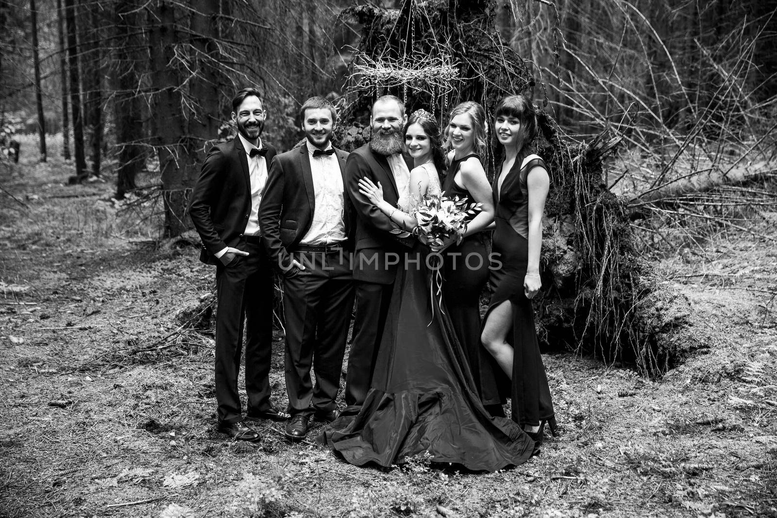 black-and-white photo in retro style.the couple and the witnesses in the background of a hut in the woods by SmartPhotoLab