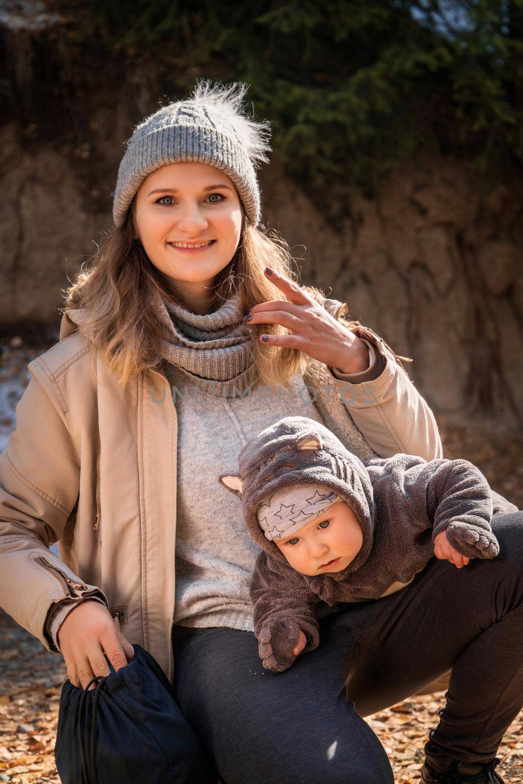 Portrait of happy young caucasian blond mother with his baby boy in travel outdoor lifestyle.
