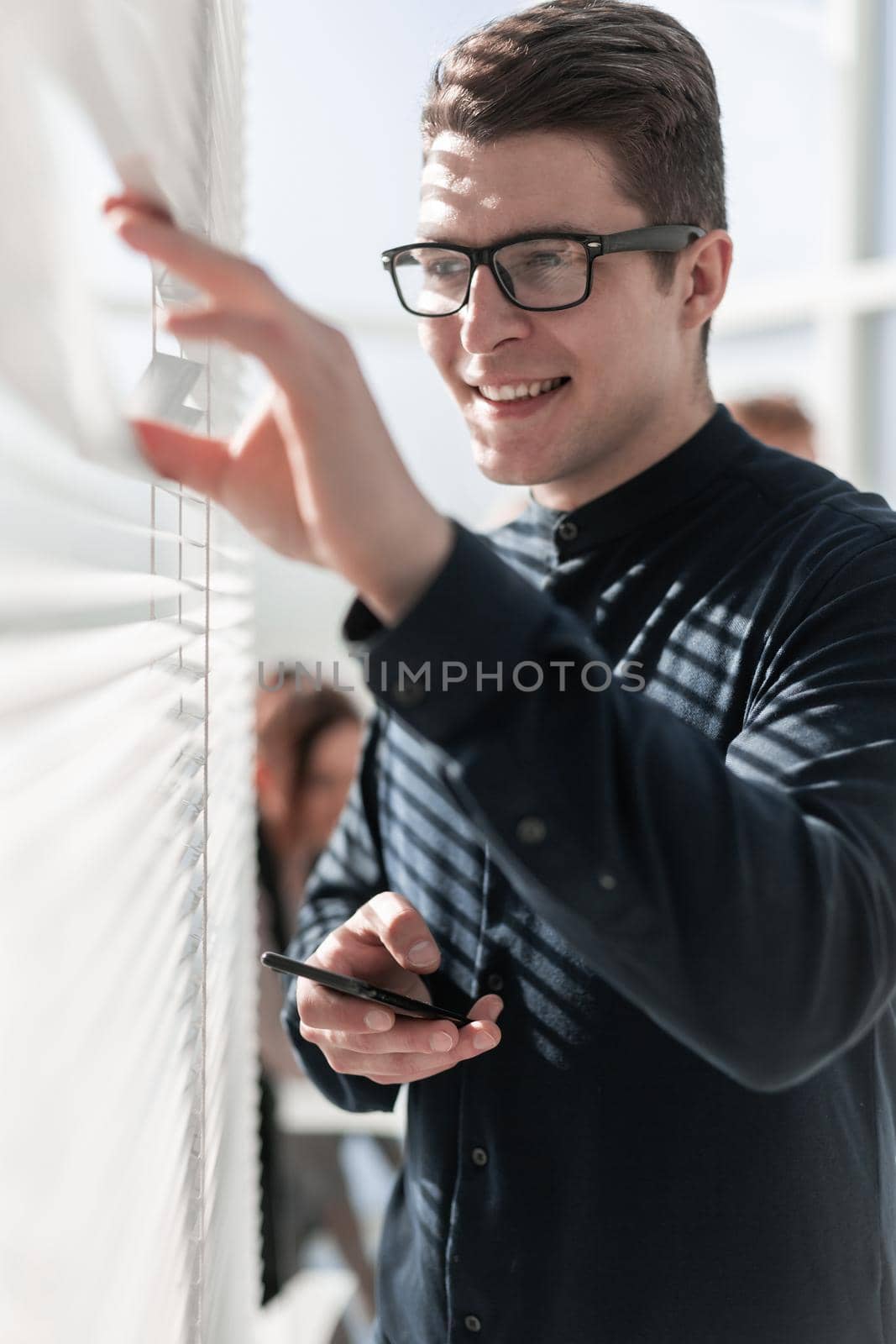 Happy businessman in office looking at window by asdf
