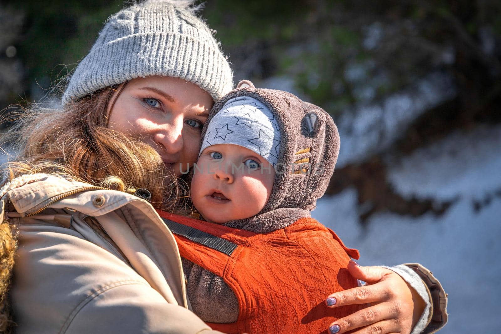 Young caucasian blond mother with his baby boy in ergonomic baby carrier in winter outdoor by Rom4ek