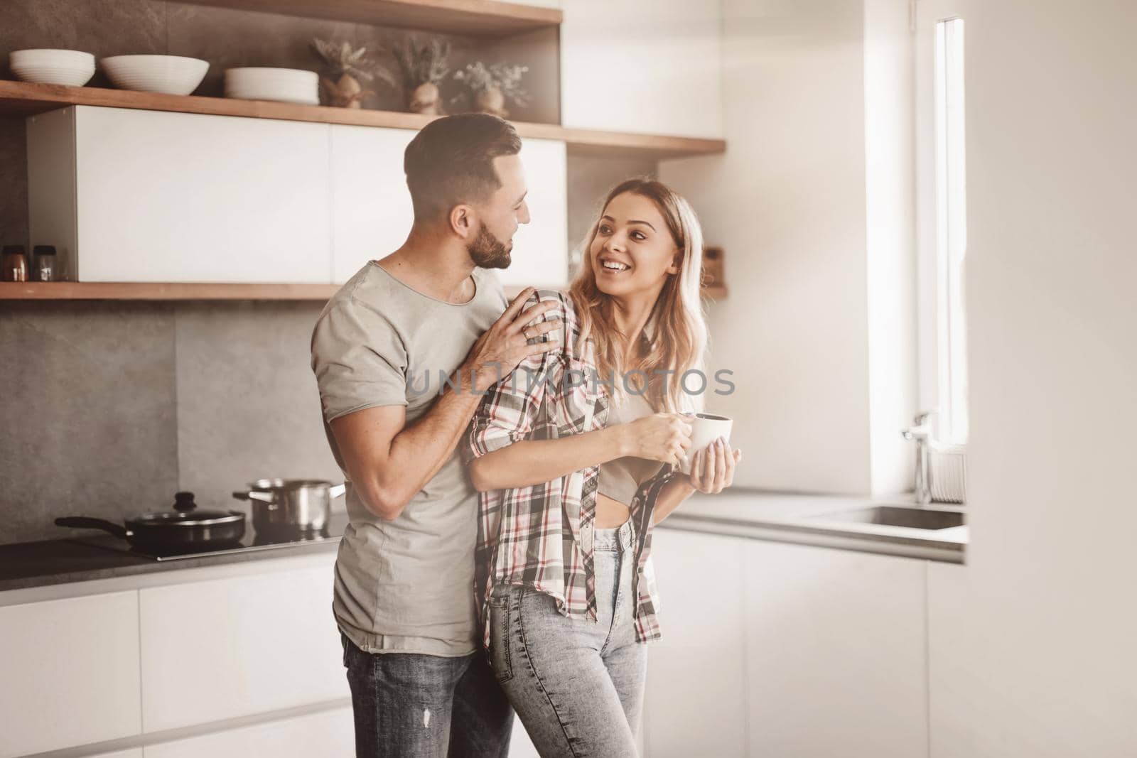 cheerful couple in the kitchen on a good morning by asdf