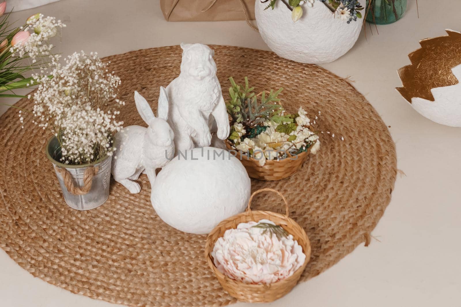 Interior floral Easter composition. Figurines of Easter bunnies and a large eggshell. The concept of home decoration for the Happy Easter holiday