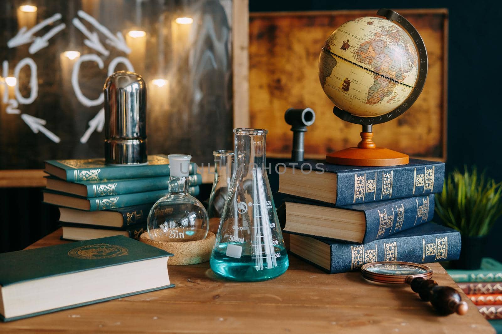 Schoolgirl perform chemical experiments. Flasks with solutions and chemical formulas on the blackboard in the school classroom. Back to school. School and preschool education.