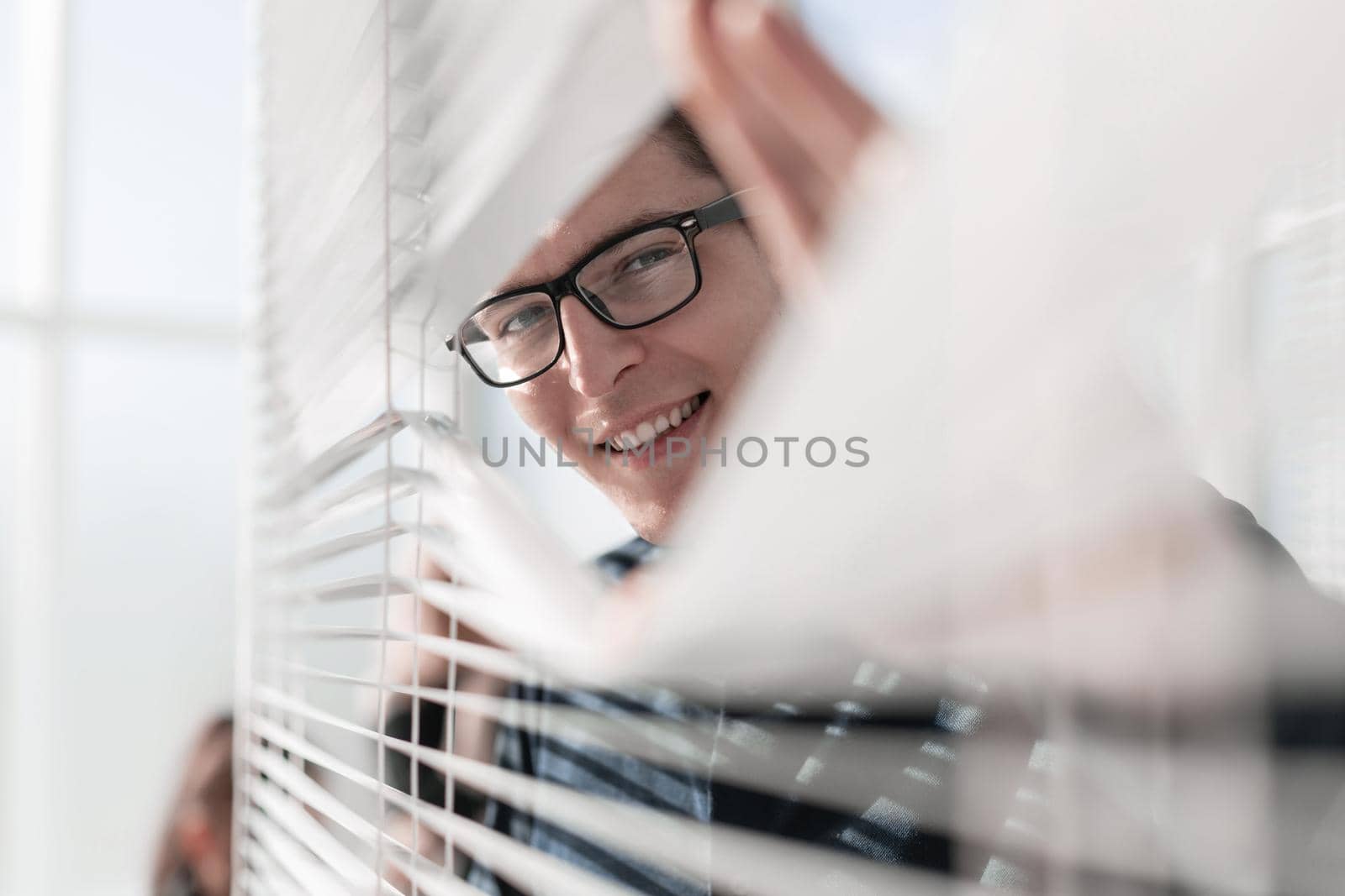 Happy businessman in office looking out the window