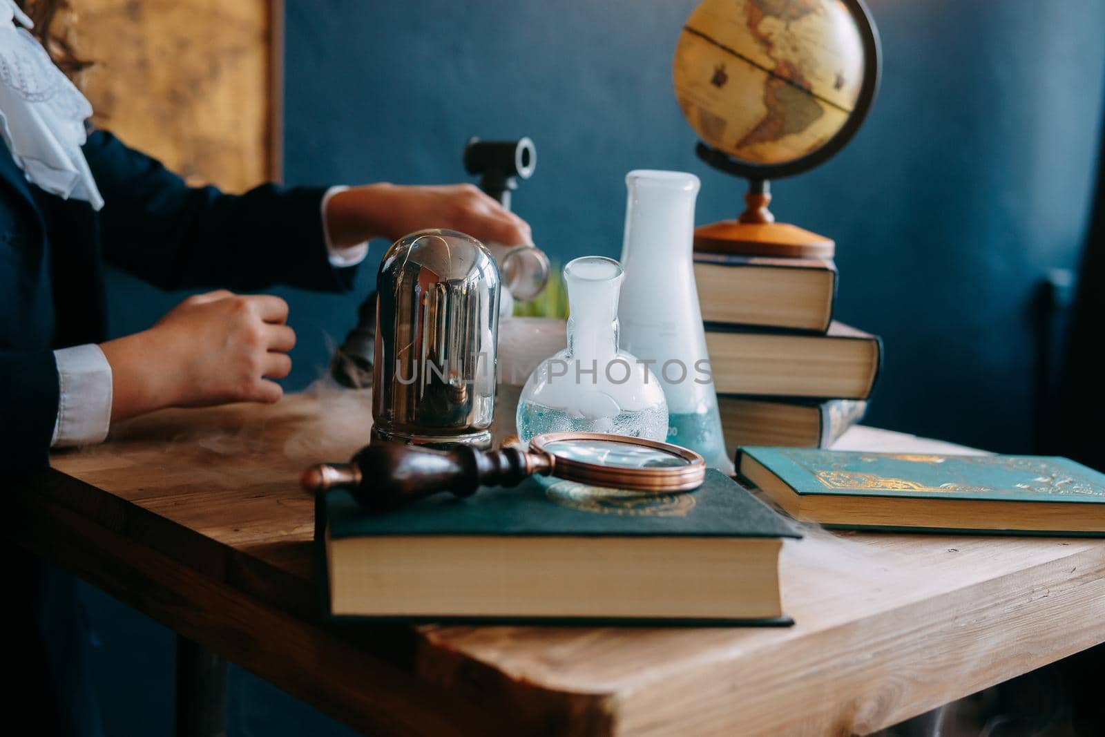 Schoolgirl perform chemical experiments. Flasks with solutions and chemical formulas on the blackboard in the school classroom. Back to school. School and preschool education.