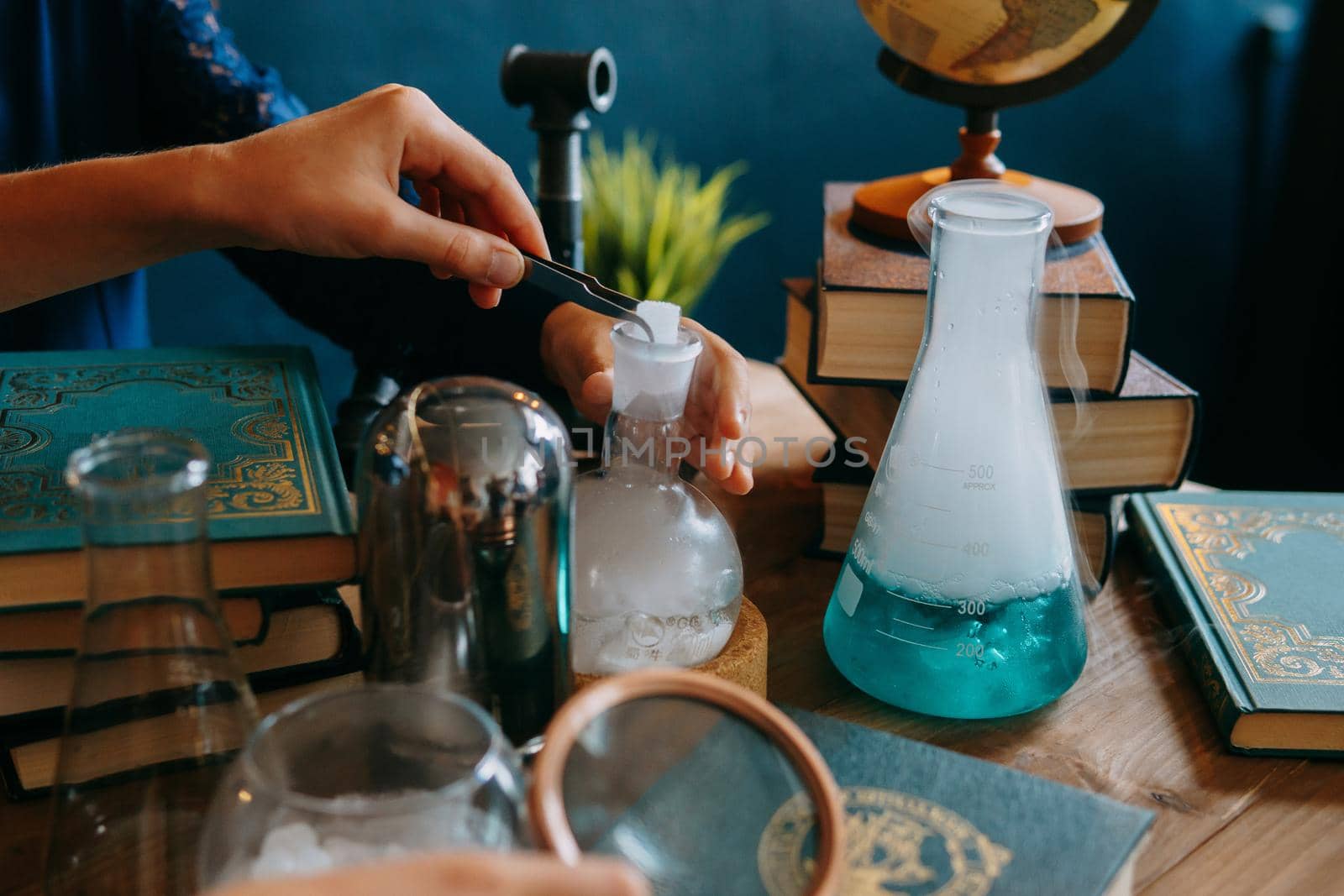 Schoolgirl perform chemical experiments. Flasks with solutions and chemical formulas on the blackboard in the school classroom. Back to school. School and preschool education.